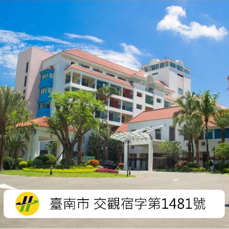 a large building with palm trees in front of it at 凱撒趣淘漫旅-台南 HOTEL CHAM CHAM Tainan in Nanxi