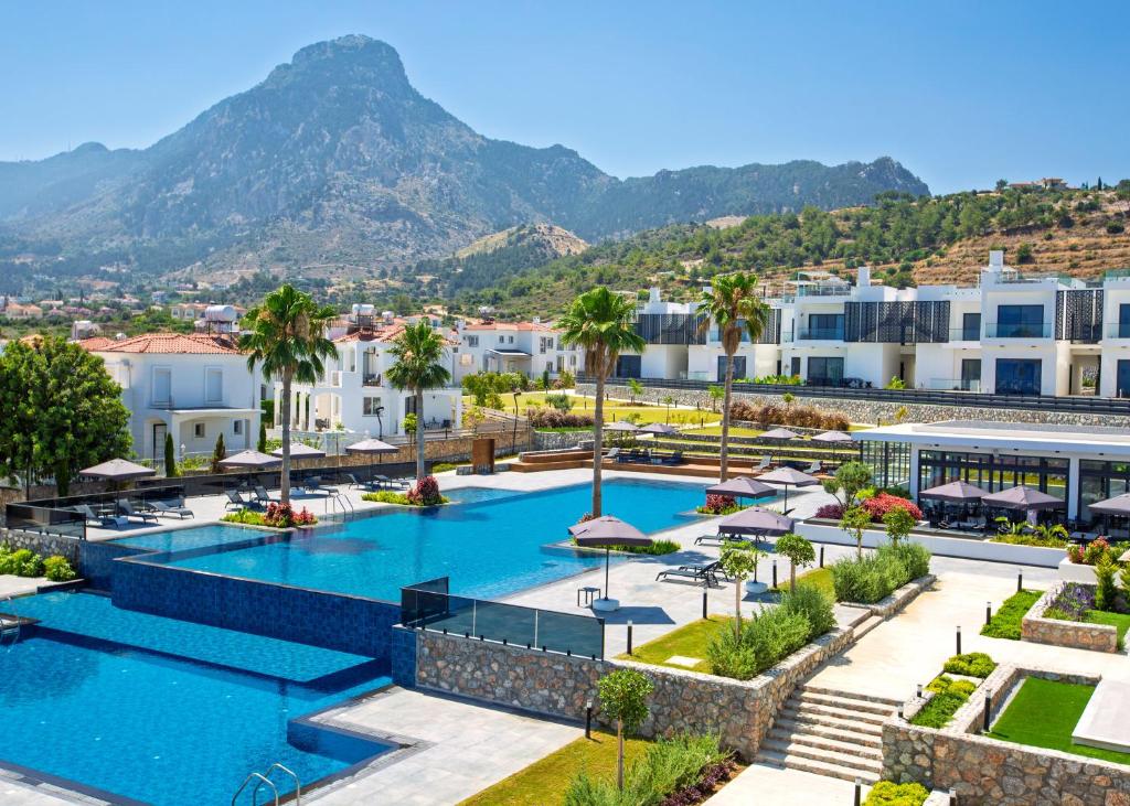 a view of the pool at a resort with mountains in the background at Aqualina C3-4 by HolidayKeys in Kyrenia