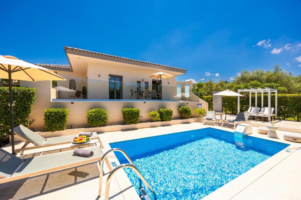 a villa with a swimming pool and a house at Villa Vatia 1 in Tragaki
