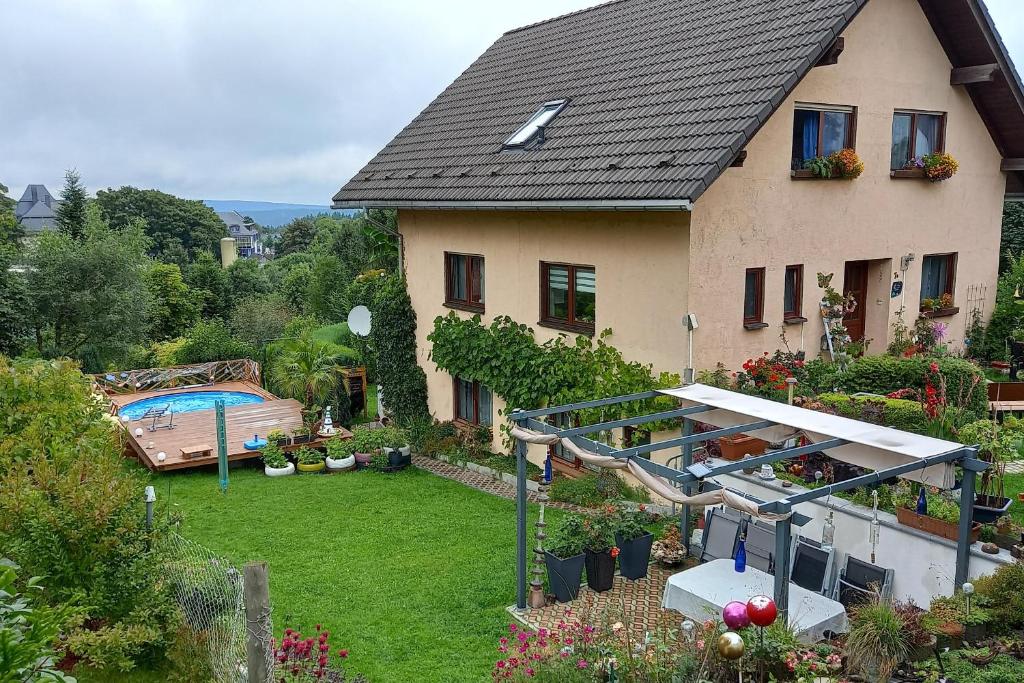 a house with a garden and a swimming pool at Ferienwohnung Am Apelsberg in Neuhaus am Rennweg