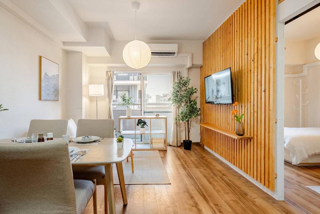 a living room with a table and a bedroom at Cozy Japandi 3LDK in Namba for Groups in Osaka