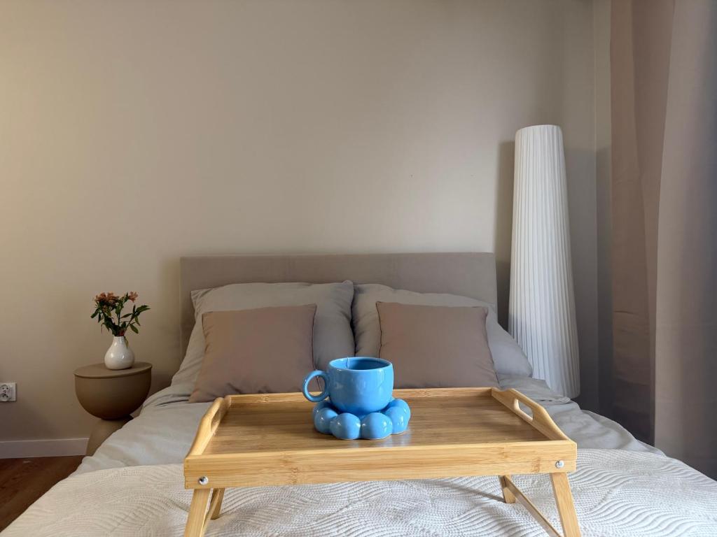 a wooden tray with a blue coffee cup on a bed at Mazury Mood kawalerka studio in Giżycko