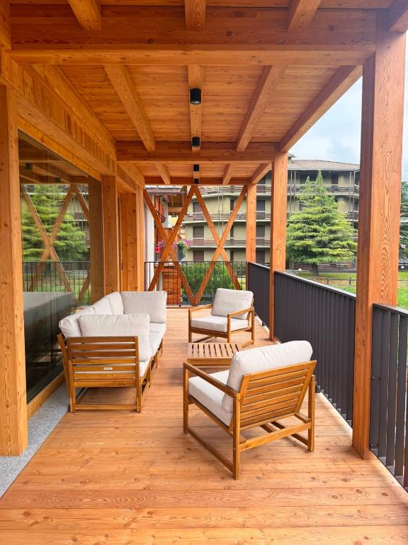 a wooden deck with benches and chairs on it at Il Fienile di Ebbe in Bormio