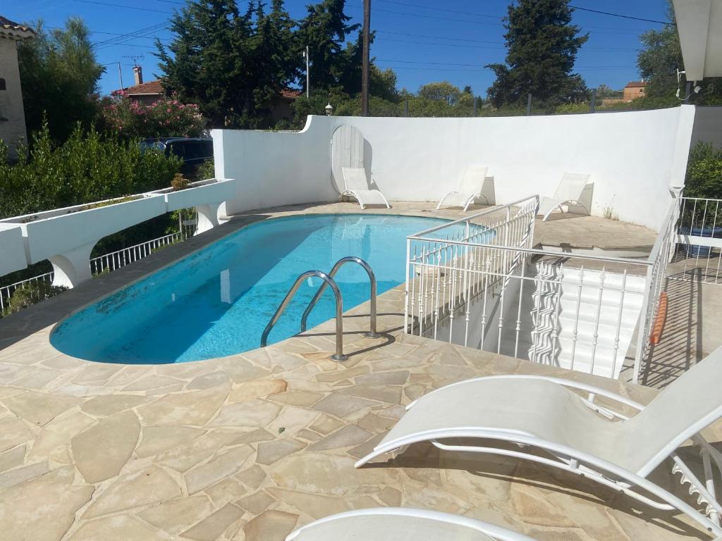 a swimming pool with chairs next to a building at Studio avec piscine et grande terrasse Parking gratuit Nice in Nice
