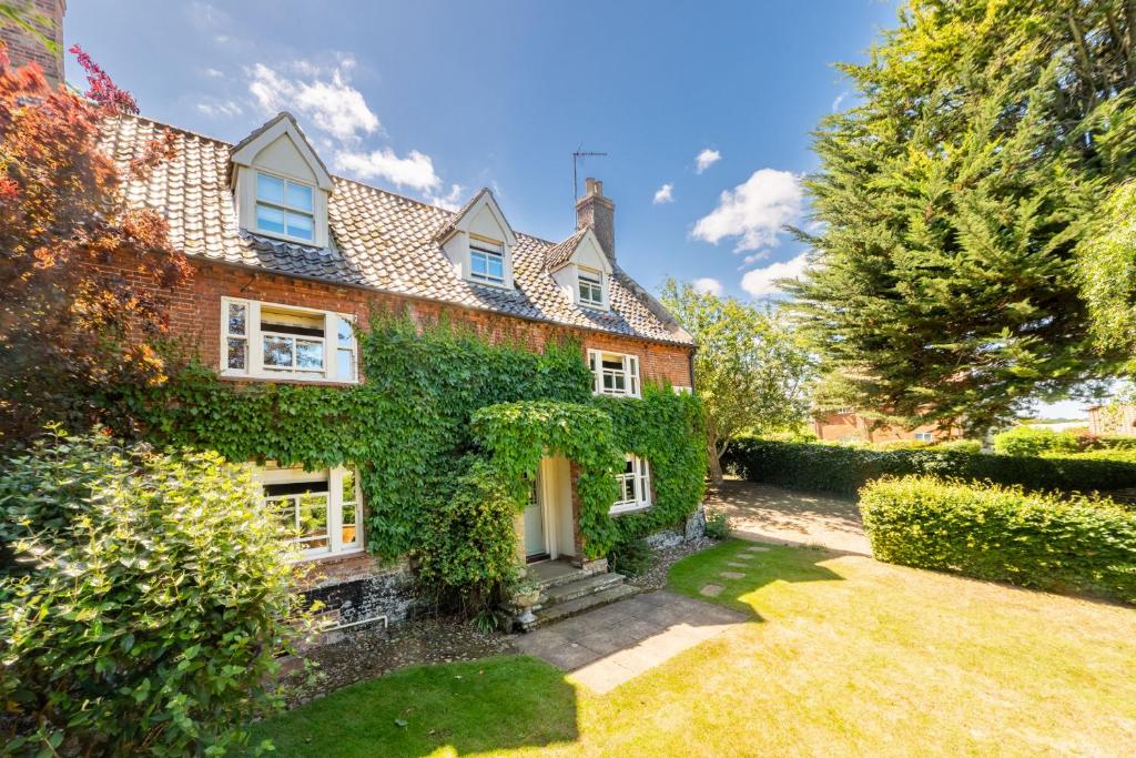 an ivy covered house with a yard at Laylands in Wells next the Sea