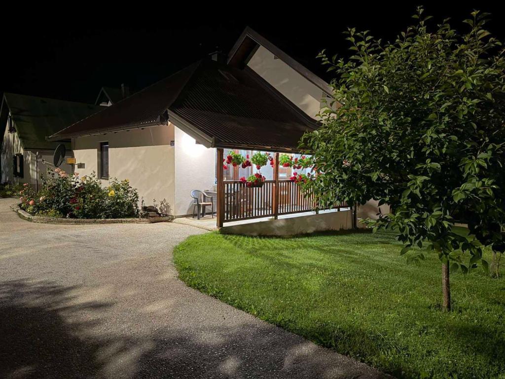a house with a fence in the yard at night at Apartman Bakic in Kolašin