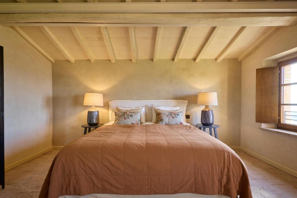 a bedroom with a large bed with two lamps at Erta Terra Hotel in Mazzolla