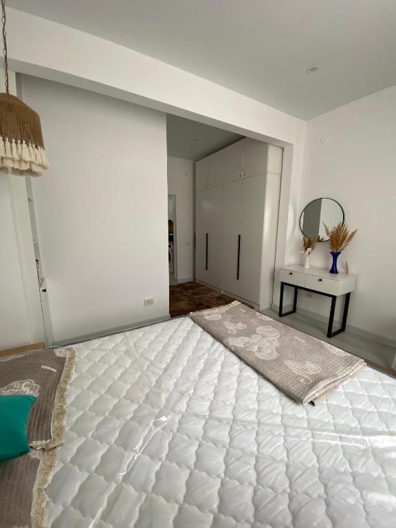 a white room with a bed and a mirror at SF Residence in Bosteri