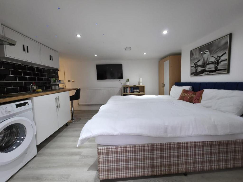 a bedroom with a large bed and a washing machine at Oxford Private Flat One in Oxford