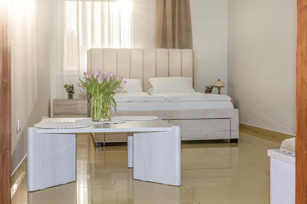a bedroom with a bed and a table with flowers on it at Virkštininkų kurortas in Vydmantai