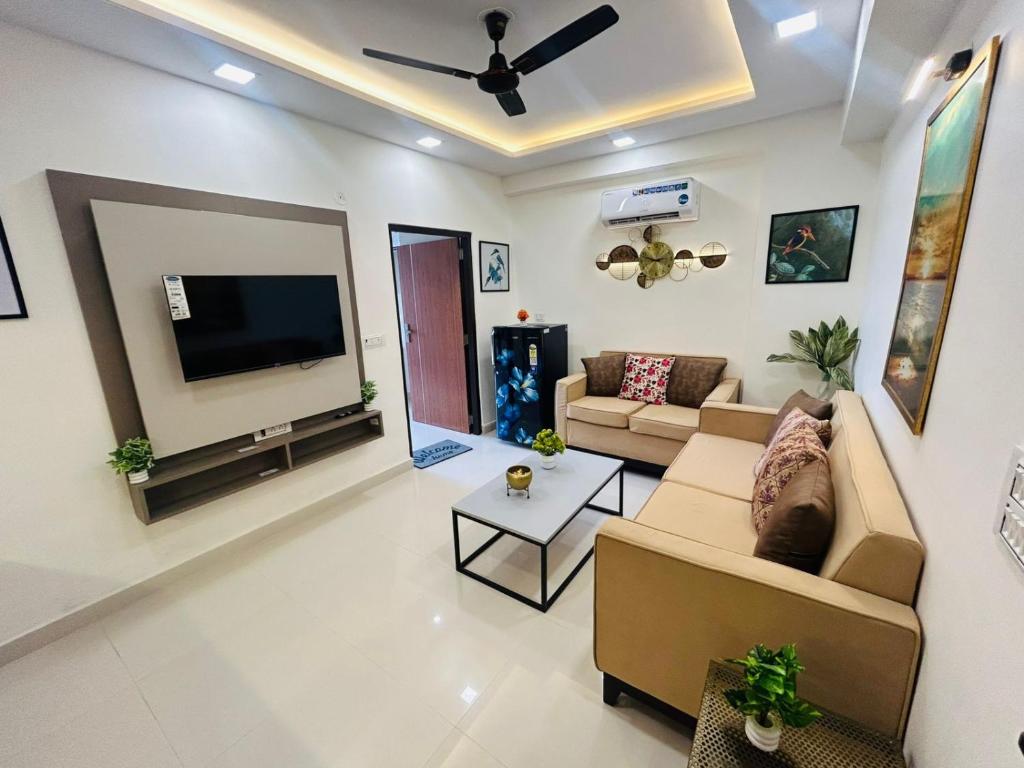 a living room with a couch and a flat screen tv at Phool Ghar by Hrittika in Siroli