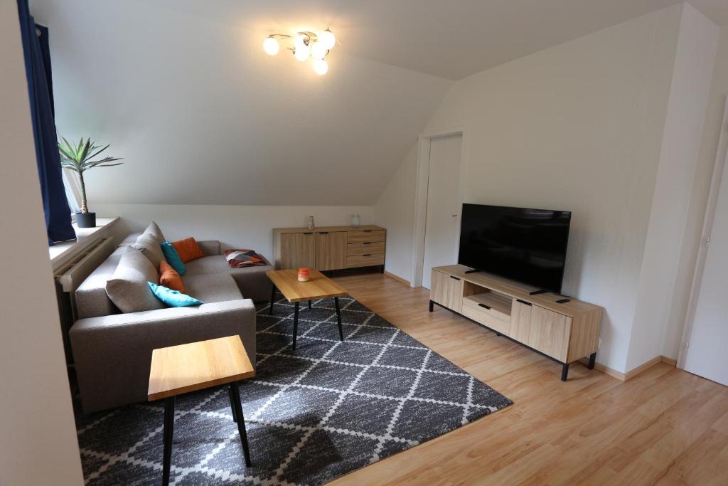 a living room with a couch and a flat screen tv at Ferienwohnung Hagge Quickborn bei Hamburg in Quickborn