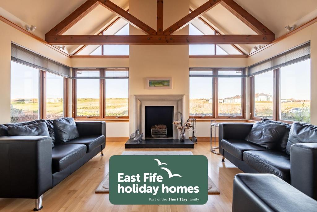 a living room with couches and a fireplace at Homeview - Elie & Earlsferry in Elie