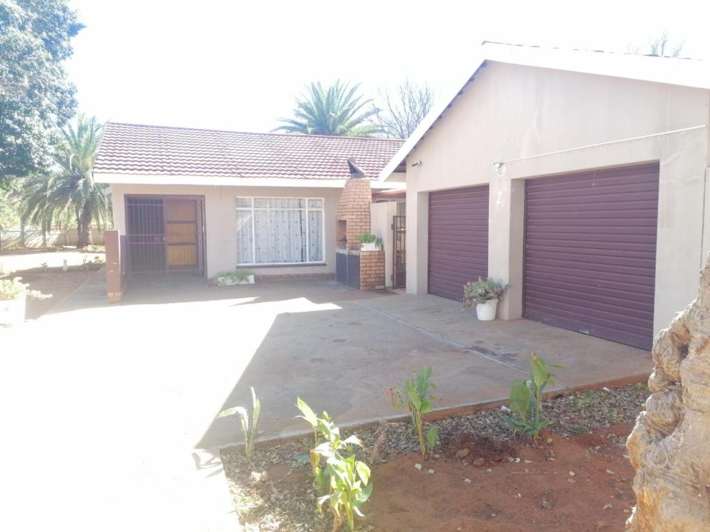 a house with purple garage doors in a driveway at Royal Oasis in Mahikeng