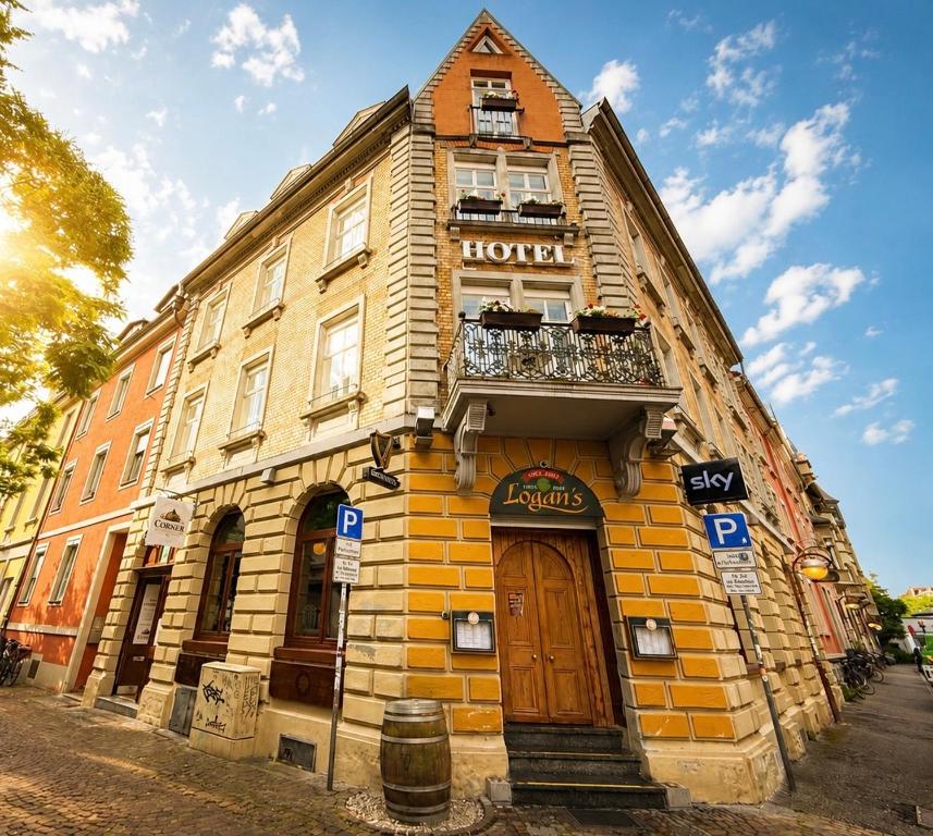 a yellow building with a balcony on top of it at Hotel TheCorner in Konstanz