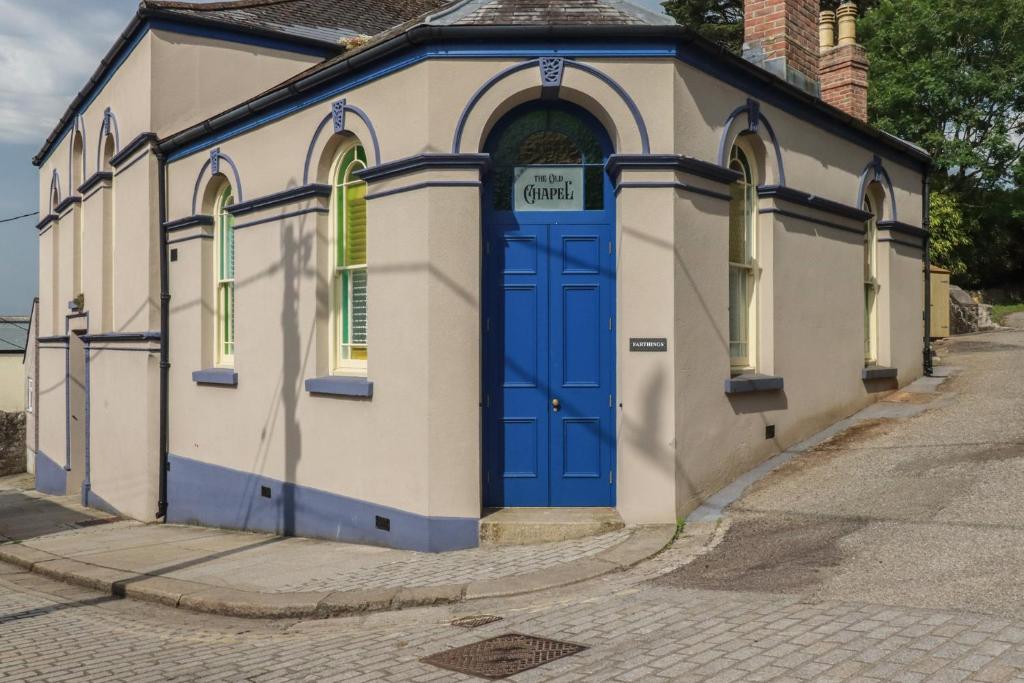 a small building with a blue door on a street at Farthings, The Old Chapel in St Austell