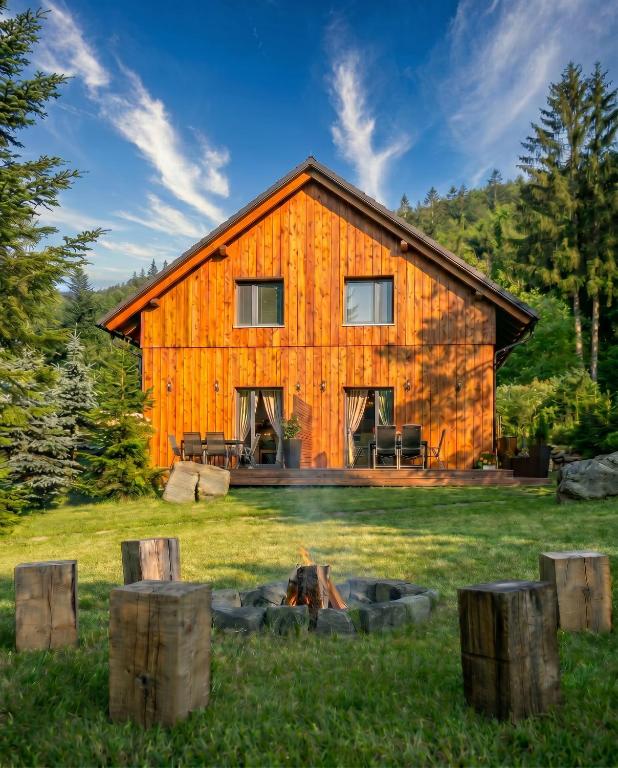 a barn with a fire in front of it at Apartmány Na Satině in Malenovice