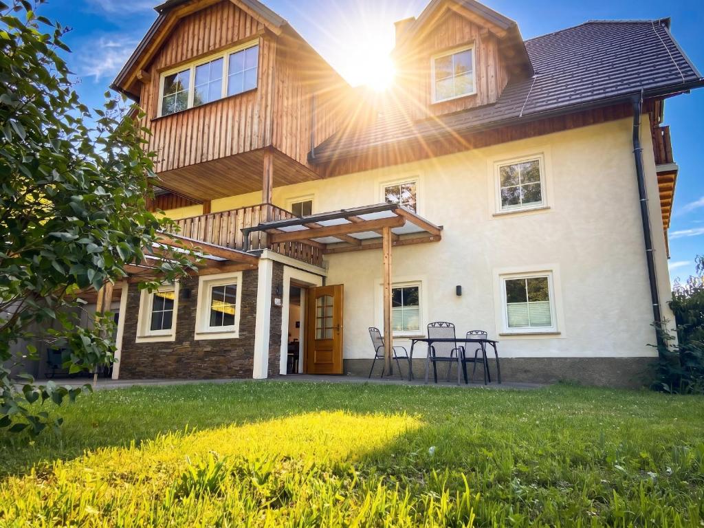 a house with the sun shining on it at Vitalhof am Kreischberg by ALPS RESORTS in Bodendorf