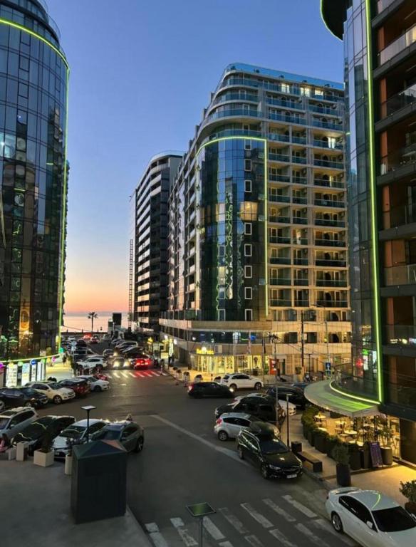 a city with cars parked in a parking lot with tall buildings at 2 минуты до моря in Batumi