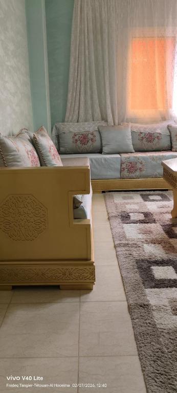 a living room with a couch and a rug at Appartement à louer wadie in Fnidek