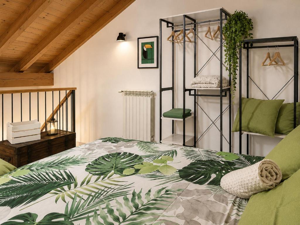 a bedroom with a bed with a green and white comforter at Lilly House Perfect stopover near Lake Como Switzerland and Milan in Fino Mornasco