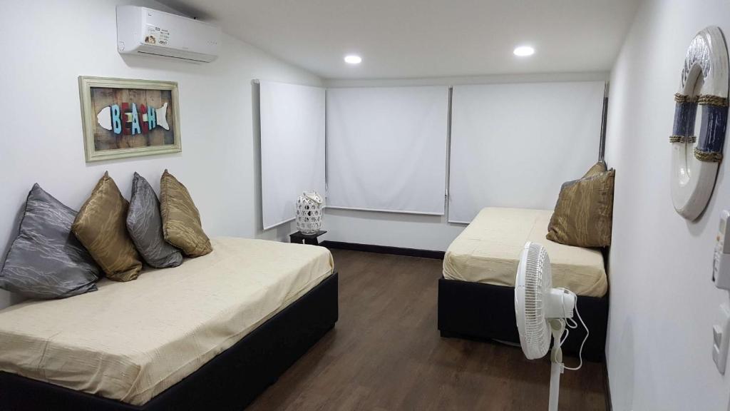 1 dormitorio con 2 camas y pared blanca en Beach Paradise Apartments, en San Andrés