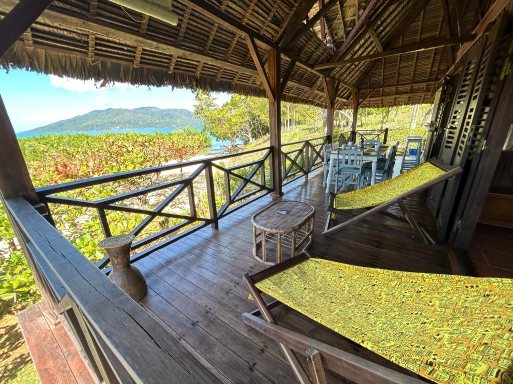 eine Veranda eines Hauses mit Stühlen und Tischen in der Unterkunft Villa TiPunch in Nosy Be