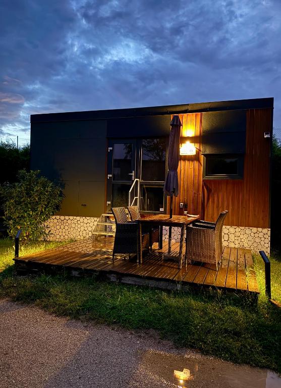 a house with a wooden deck with a table and chairs at Tinyhaus Altmühlauszeit in Beilngries