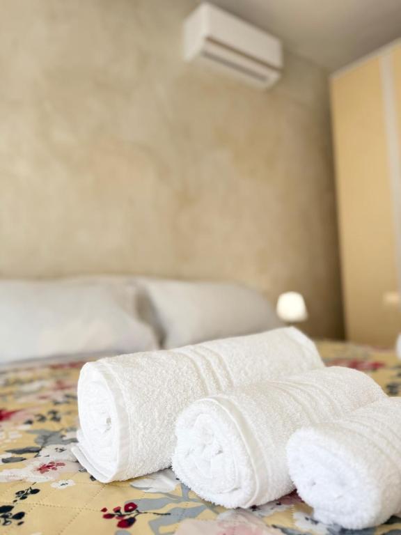 two rolled towels sitting on top of a bed at Mare e Monti a 5 minuti dal mare in Furnari