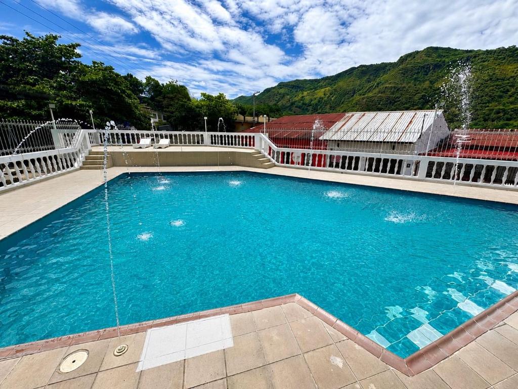 a large swimming pool with a fountain in front of a building at Hotel La Popa Honda Tolima in Honda