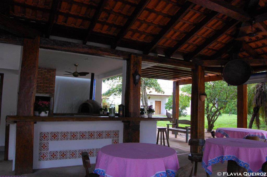 Pousada Pequi في Baía: غرفة معيشة مع طاولات أرجوانية ومدفأة