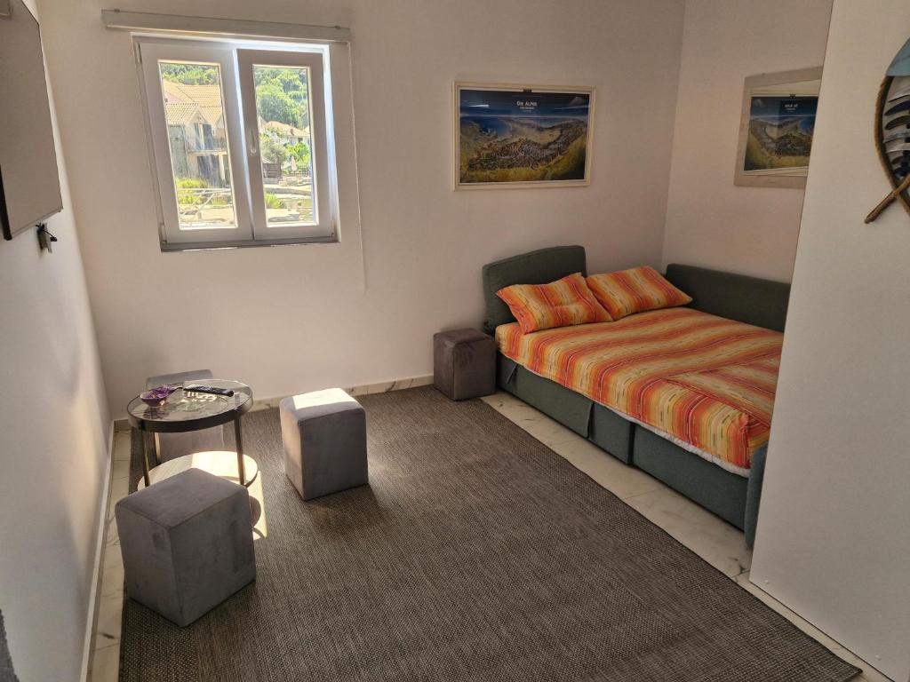 a small bedroom with a bed and a window at Apartman UNA in Bjelila