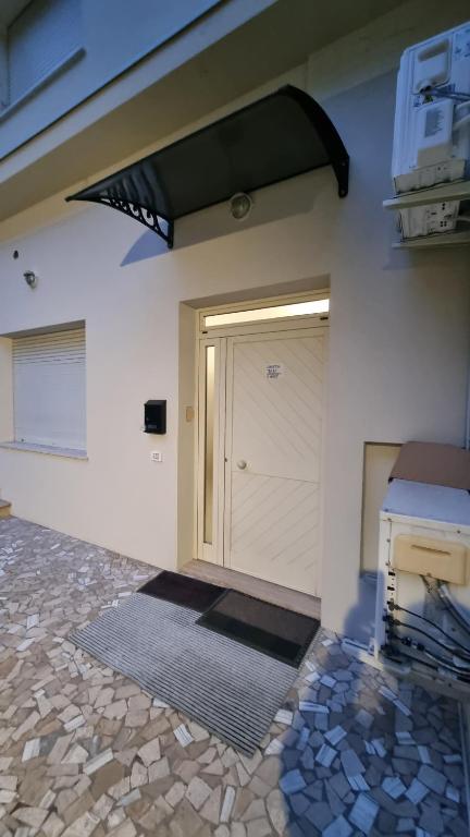 a garage with a white door and a tile floor at Casetta Mary in Teramo