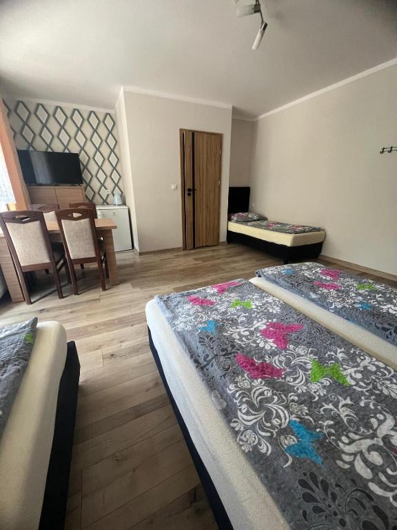 a bedroom with two beds and a table with a piano at Baracuda in Dębki