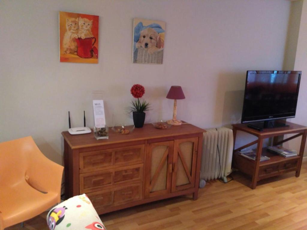 a living room with a television on a wooden cabinet at Apartamento Cabañal in Cullera