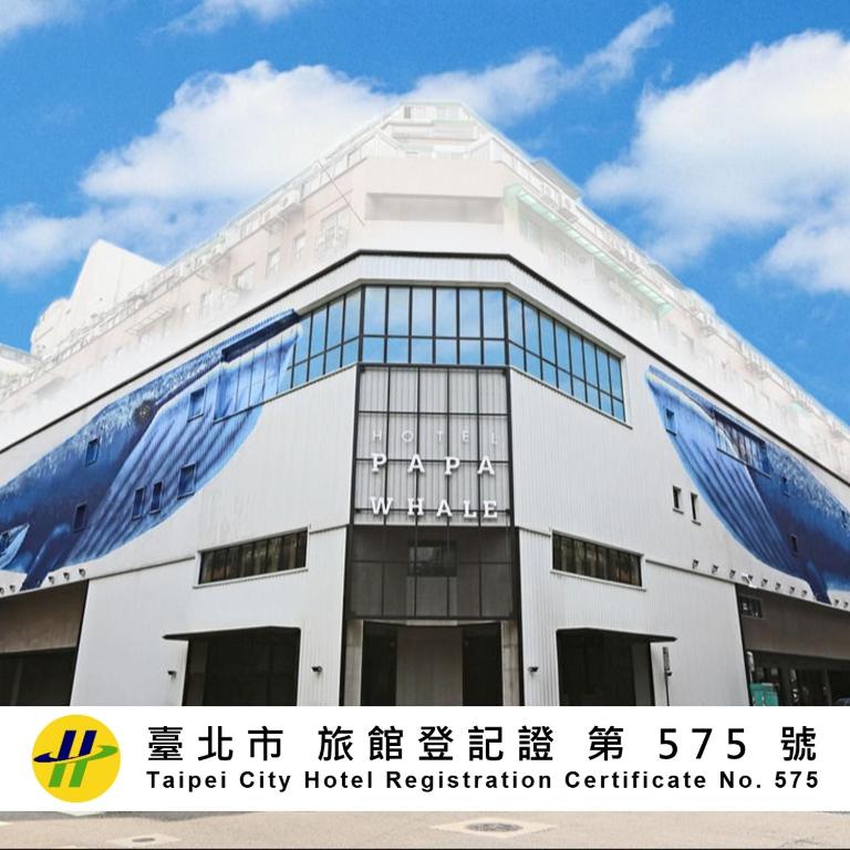 a building with a blue and white facade at Hotel PaPa Whale in Taipei