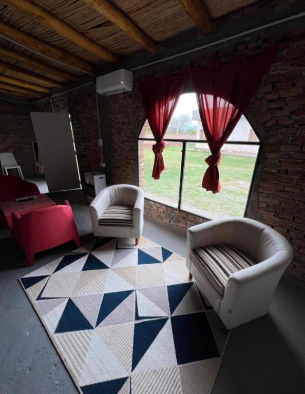 a living room with two couches and a large window at Cabaña San Antonio2 in Tinogasta