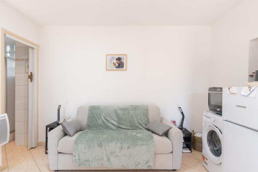 a living room with a couch and a washing machine at My Alba in Jaujac