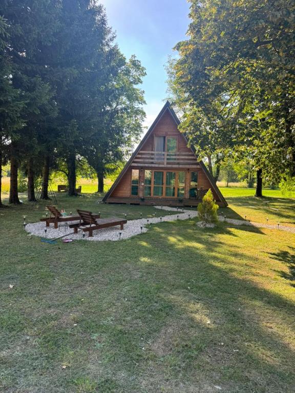 a cabin in a field with benches and trees at Careva staza in Nikšić