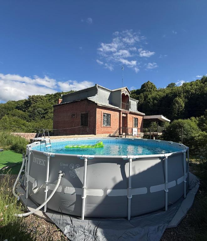 a large swimming pool in front of a house at Гостевой Дом на природе in Vanadzor