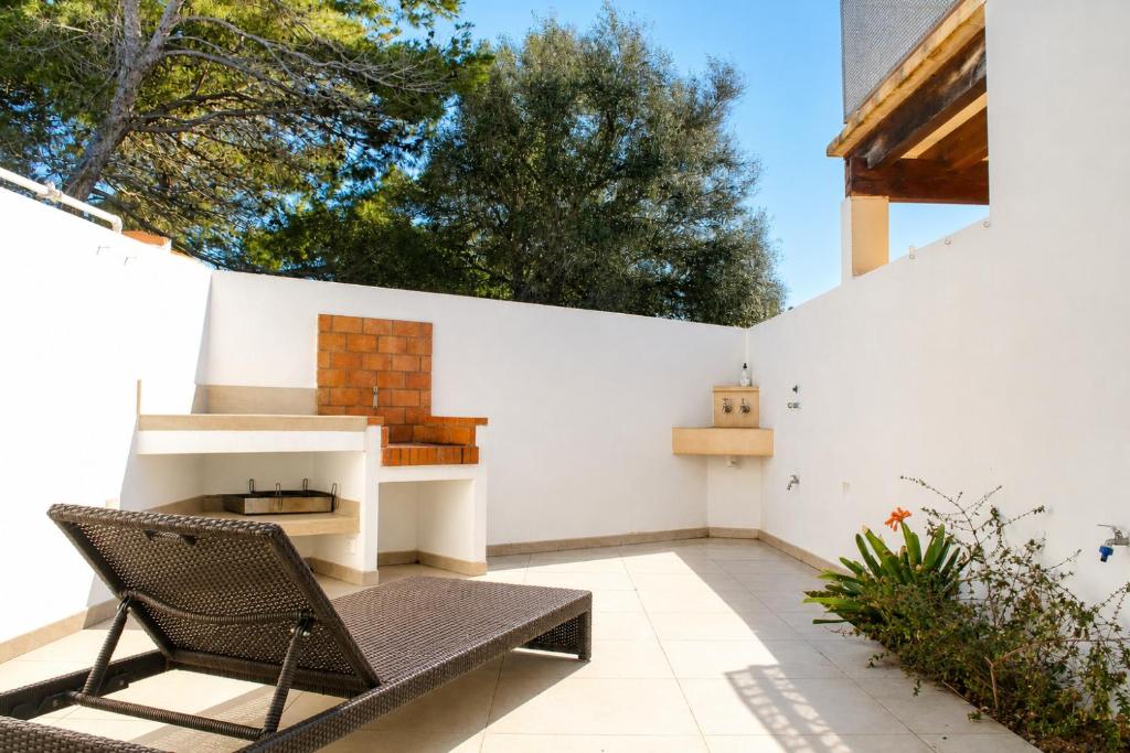 a patio with a chair and a wall at Casa de vacances Els Arbocers in Cala Blanca