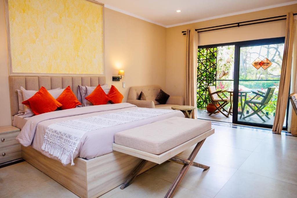 a bedroom with a large bed with orange pillows at Bakadaji Hotel in Serekunda