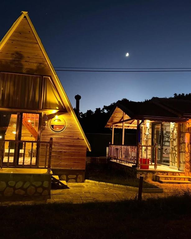 a couple of buildings at night with the moon at Çameli doğa hotel in Belevi