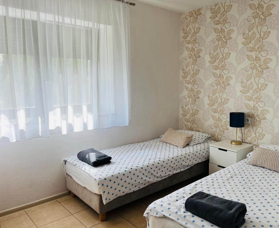 a bedroom with two beds and a window at Pokoje Gościnne u Kovi in Legnica