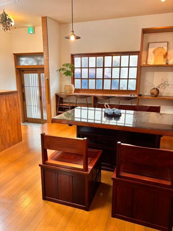 a large kitchen with a counter and two chairs at 古民家一棟貸切 民宿 潤 松山市駅徒歩5分 銀天街徒歩2分 無料駐車場1台付き in Matsuyama