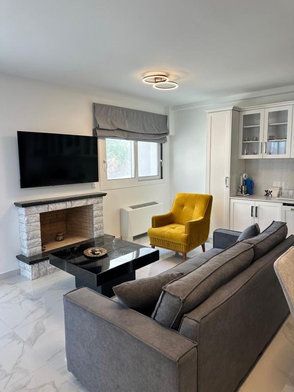 a living room with a couch and a tv at Nōema Residences II in Nafpaktos
