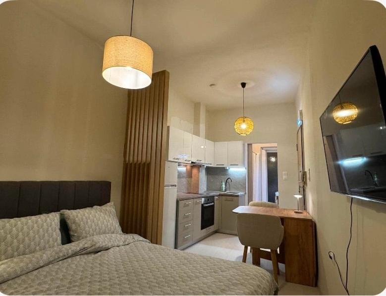 a bedroom with a bed and a table and a kitchen at Jasmine Studio 3 Pigadia Siatista in Siátista