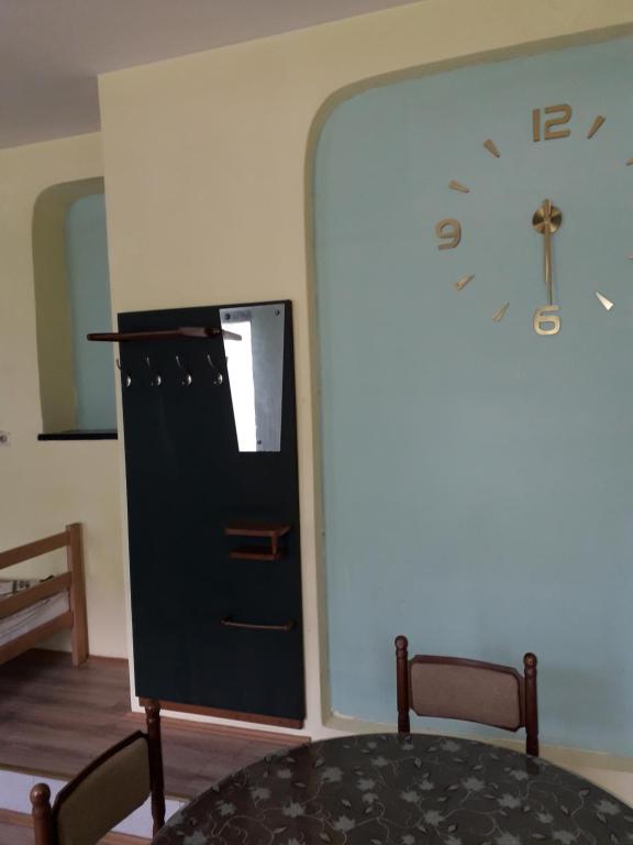 a room with a table and a clock on a wall at Petrovic in Sombor