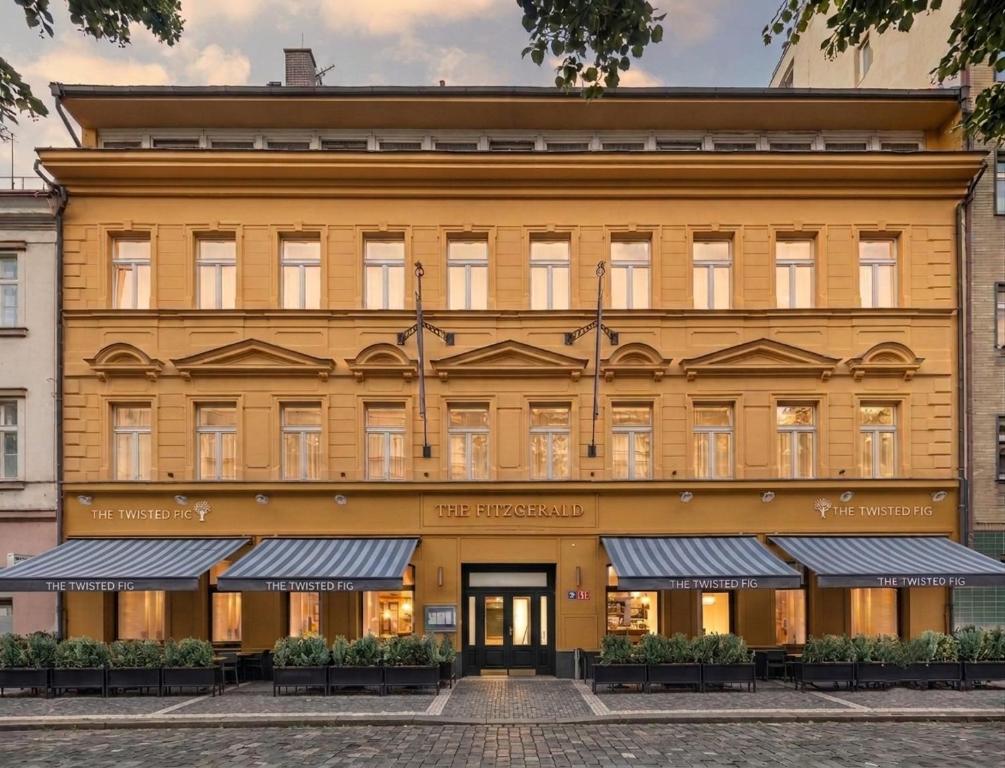 a large yellow building with a store front at The Hotel Fitzgerald in Prague