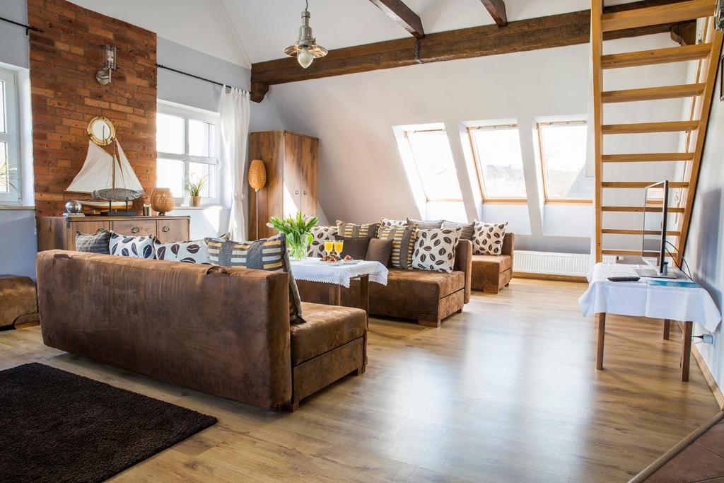 una sala de estar con 2 sofás y una escalera en Dom Wakacyjny Mistral, en Ustka